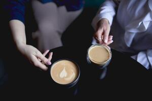 gammal mor och medelålders dotter dricka kaffe och talande i de Kafé foto