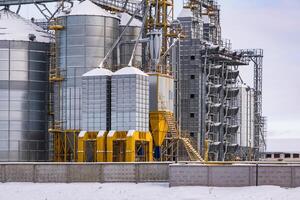 agroindustriell komplex med silos och en utsäde rengöring och torkning linje för spannmål lagring i snö av vinter- fält foto