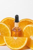 kosmetisk flaska produkt serum vitamin c med orange skivor på vit bakgrund, mockup, kopia Plats foto