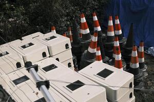 vägspärrar och byggnad material staplade i ett öppen Plats foto