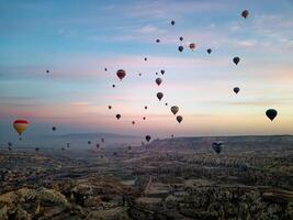 varm luft ballong flyg i goreme i Kalkon under soluppgång. rida i en varm luft ballong, de mest populär aktivitet i Kappadokien. romantisk och känd resa destination. foto