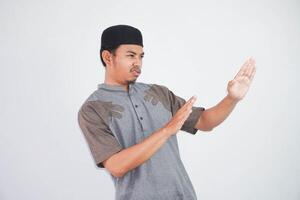 allvarlig ung asiatisk muslim man händer gör sluta gest och demonstrerar avslag bär kurta kläder isolerat på vit bakgrund foto