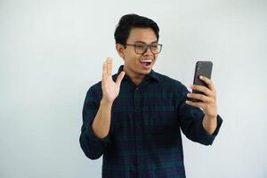 ung asiatisk man ser till hans mobil telefon med Wow uttryck isolerat på vit bakgrund. foto