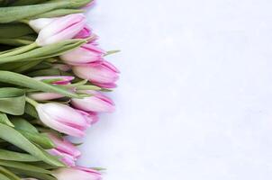 blommig bakgrund med tulpaner blommor på blå abstrakt bakgrund. platt lägga, topp se. härlig hälsning kort med tulpaner för mödrar dag, bröllop eller Lycklig händelse foto