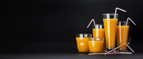 glasögon av orange juice på svart bakgrund med kopia Plats foto