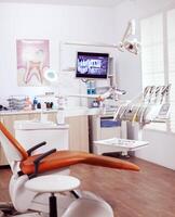 interiör av tömma rörelse rum i dental klinik. stomatologi skåp med ingen i den och orange Utrustning för oral behandling. foto