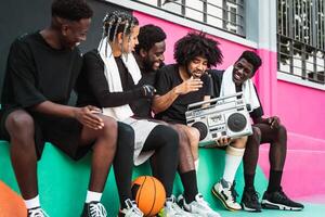 ung afro amerikan människor har roligt lyssnande musik med årgång boombox utomhus- - urban gata människor livsstil foto