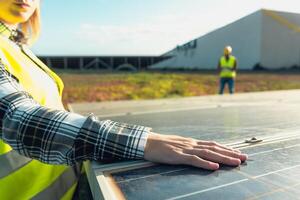 ung kvinna ingenjör arbetssätt för alternativ energi med vind turbin och solceller sol- panel - innovation och grön kraft begrepp foto