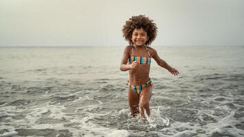 afro barn har roligt spelar inuti hav vatten under sommar högtider - barndom och resa semester begrepp foto