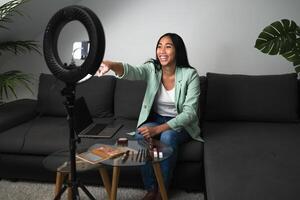 ung kvinna vlogging uppkopplad med smartphone kam och ringa led från Hem levande rum - ungdom människor med social media och smart arbetssätt begrepp foto