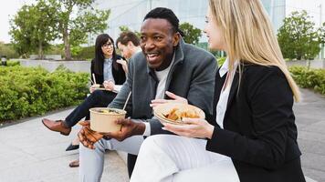 Lycklig raser företag människor har en lunch ha sönder utanför kontor foto