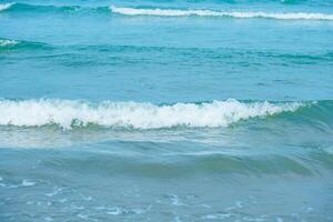 vågor på de strand. blå hav Vinka. blå vatten yta textur med krusningar, stänk, och bubblor. abstrakt sommar baner bakgrund vatten vågor i solljus med kopia Plats kosmetisk fuktighetskräm. foto
