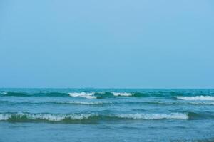vågor på de strand. blå hav Vinka. blå vatten yta textur med krusningar, stänk, och bubblor. abstrakt sommar baner bakgrund vatten vågor i solljus med kopia Plats kosmetisk fuktighetskräm. foto