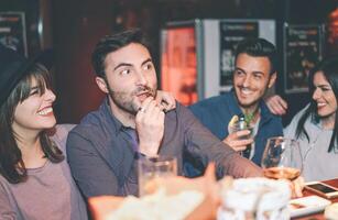 Lycklig vänner har roligt dricka cocktail i en bar - ung trendig människor skrattande och njuter tillsammans de helgen nattliv - ungdom fest livsstil begrepp foto