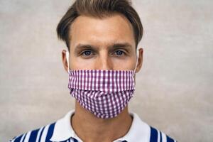 ung man bär ansikte skyddande mask till undvika korona virus spridning - hälsa vård begrepp foto