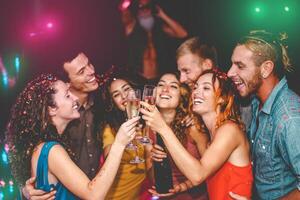 Lycklig vänner fira ny år eve högtider i disko klubb - ung människor håller på med privat fest med deejay och dricka champagne - ungdom kultur underhållning livsstil begrepp foto