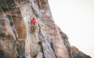 atletisk man klättrande en sten vägg - klättrare Träning och utför på en kanjon berg - begrepp av extrem sport, människor hälsa livsstil och bergsklättring foto