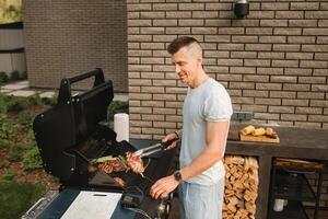 en man på de gata är matlagning en biff på de grill på en utegrill foto