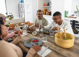 Lycklig svart familj njuter medan har friska lunch tillsammans på Hem - mat och föräldrar enhet begrepp foto