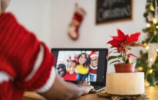 Lycklig afrikansk familj har video ring upp på dator under jul högtider foto