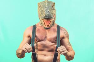 passa senior man bär t Rex dinosaurie mask - galen hipster kille har roligt fira maskerad karneval högtider - absurd och overkligt rolig begrepp - akvamarin bakgrund foto