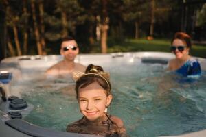 i sommar, de familj vilar i de utomhus- varm badkar foto