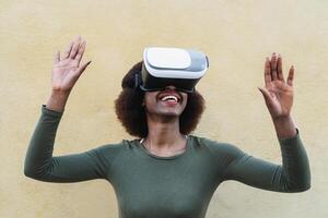 afro kvinna använder sig av virtuell verklighet glasögon utomhus- - Lycklig ung flicka har roligt med förnyat vr googlar teknologi - tech livsstil underhållning och 3d spel erfarenhet begrepp foto