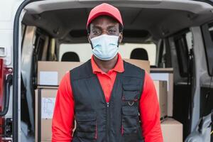 afrikansk leverans man arbetssätt medan bär ansikte mask till undvika korona virus spridning - människor arbetssätt med snabb leverera under korona virus utbrott foto