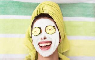 Lycklig flicka applicering ansiktsbehandling lera mask - ung kvinna har hud vård spa dag - skönhet rena behandling dag och kosmetologi Produkter begrepp foto