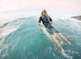 ung man har roligt surfing på hög vågor hav - sportig surfare håller på med Träning övningar på blå vatten - extrem sport och hälsa semester livsstil människor foto