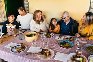 Lycklig latin familj har roligt lunch tillsammans på Hem foto