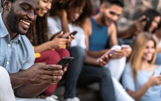 ung raser grupp av vänner använder sig av mobil smartphone Sammanträde på urban trappa - ungdom tusenåriga livsstil begrepp foto