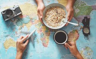 topp se händer människor planera semester med värld Karta medan håller på med frukost med flingor mjölk - par få redo för Nästa värld Turné - begrepp av äventyr, turism, och reser människor livsstil foto