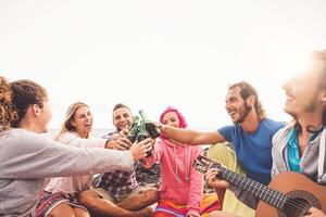 Lycklig vänner har roligt toasting öl Nästa de strand - ung människor camping och dricka utomhus- - sommar högtider och ungdom semester livsstil begrepp foto