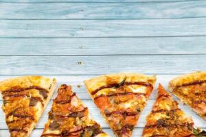 massor av utsökt triangel- pizza skivor på en blå trä- bakgrund foto