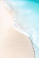 en se från en höjd av en tropisk strand och vågor brytning på en tropisk gyllene sandig strand. de hav vågor försiktigt vind längs de skön sandig strand foto