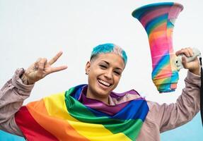 ung kvinna fira Gay stolthet händelse bär regnbåge flagga symbol av HBTQ social rörelse foto