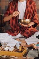 tibetan sång skål i de händer av en man under en te ceremoni foto