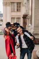 en eleganta familj av tre promenader genom de höst stad Framställ för en fotograf . pappa, mamma och dotter i de höst stad foto