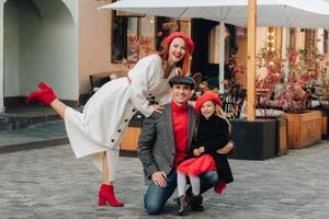 en eleganta familj av tre promenader genom de höst stad Framställ för en fotograf . pappa, mamma och dotter i de höst stad foto