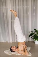 en man med en bar torso gör yoga i en kondition rum. de begrepp av en friska livsstil foto