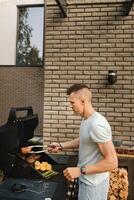 en man på de gata är matlagning en biff på de grill på en utegrill foto