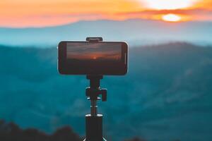en smartphone är inspelning de Sol miljö över en berg räckvidd. foto
