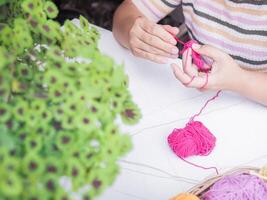 närbild av kvinna hand stickning med rosa ull foto