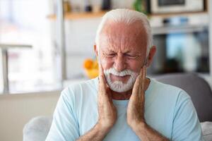 tand smärta och tandvård. senior man lidande från fruktansvärd stark tänder smärta, rörande kind med hand. känsla smärtsam tandvärk. dental vård och hälsa begrepp. foto