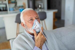 sjuk äldre man framställning inandning, medicin är de bäst medicin. sjuk senior man bär ett syre mask och genomgå behandling för covid19. senior man med ett inhalator foto