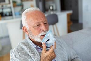 sjuk äldre man framställning inandning, medicin är de bäst medicin. sjuk senior man bär ett syre mask och genomgå behandling för covid19. senior man med ett inhalator foto