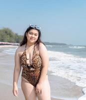 porträtt ung asiatisk kvinna fett knubbig söt skön leende Lycklig roligt njut av koppla av bikini badkläder kropp sexig främre se hav strand vit sand rena blå himmel lugna natur hav Vinka vatten resa på Semester foto