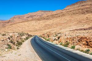 ändlös väg i sahara öken- med blå himmel, marocko afrika foto