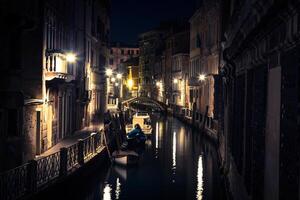 se in i en liten kanal i Venedig på natten foto